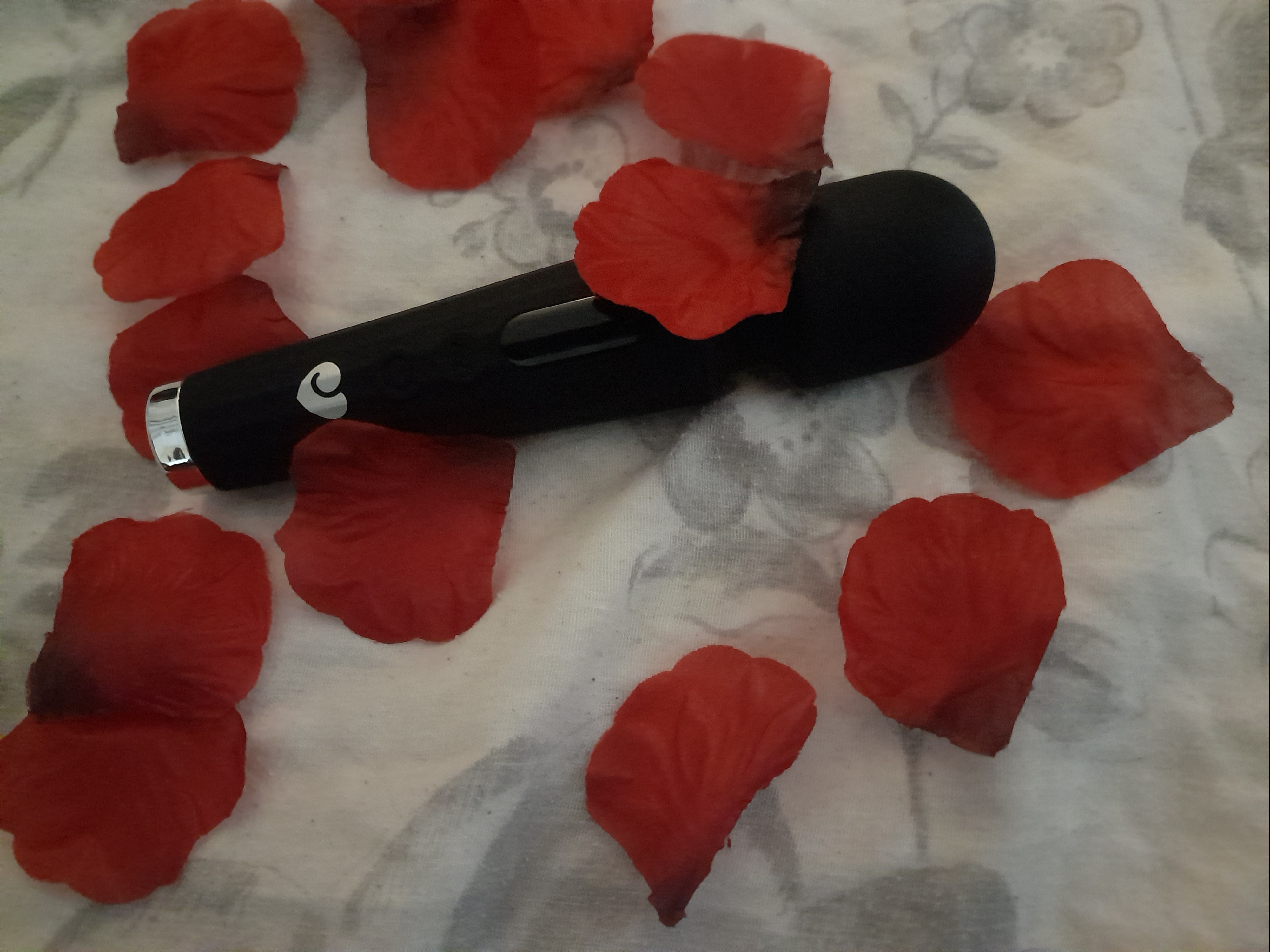 Lovehoney Power Play Rechargeable Wand Vibrator covered in red silk rose petals